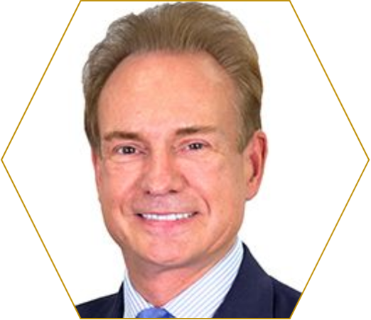 This a portrait image of Jonathan Moulds, CBE. He is wearing a suit and tie, looking directly at the camera and smiling.